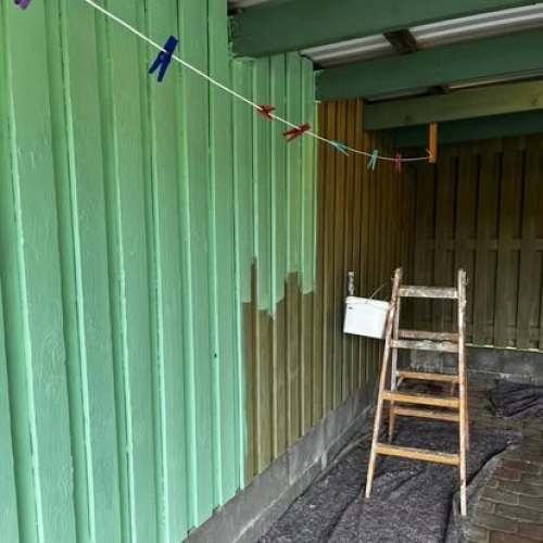 Udendørs malerarbejde hvor træbeklædning males grøn i Kalundborg